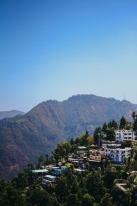 a village on a hill with a mountain in the background